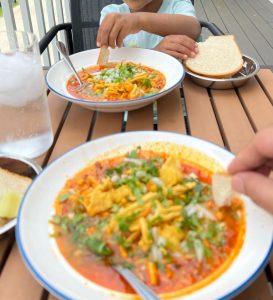 Sampling the taste of Misal Pav tarrie by dipping some pav in it