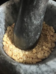 Danyache koot, coarse crushed peanut from roasted peanuts in a mortar and pestle